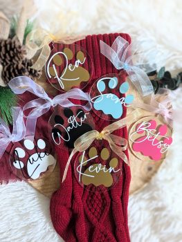 Add a personal touch to your Christmas tree this year with our Handmade Personalized Christmas Baubles! Crafted from 2mm clear acrylic and beautifully personalized with your pet&rsquo;s name in vinyl, these baubles are a perfect keepsake to celebrate a special first Christmas or simply add charm to your d&eacute;cor. Each bauble comes with a delicate organza ribbon and is available in a variety of paw colours to match your style. They also make thoughtful gifts! Choose your ribbon and paw colour&mdash;name will appear in white.