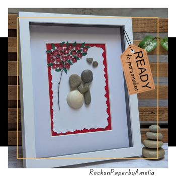 Celebrate a love that has blossomed over four decades with this exquisite Ruby Wedding Anniversary pebble art.Each piece is a testament to enduring affection, featuring a couple in a tender embrace beneath a tree adorned with red ruby paper flowers&mdash;symbolizing 40 years of shared memories. The artwork is brought to life with a fallen branch and dark green leaves, adding a touch of nature&rsquo;s serenity.Handpicked pebbles from the beautiful beaches of Ireland represent the couple&rsquo;s strong foundation, while the girl is delicately crafted from a beautiful beach shell, capturing the unique journey of love.Personalize this heartfelt creation with your chosen names and a special date, making it a one-of-a-kind memento. Select from a variety of background colors and frame options to match your decor and commemorate this milestone anniversary in style.A treasure trove to give them on their anniversary.Made to order only, this picture comes on a frame of approximately 9x11 inches. It can be wall hanged or rested on a table.
Based in Carrigaline, East Cork - Ireland, I ship worldwide. If your destination country is not listed, please contact me and I'll give you a quote for the shipping charges to your specific location.All pieces are my own design and created with a lot of love using natural materials collected on my walks along the beautiful Irish beaches and woods. Please visit my store RocksnpaperbyAmelia for more gift ideas.
https://www.shopinireland.ie/sellers/rocks-and-paper-by-amelia
Thank you for supporting my handmade store.AmeliaP.S. If you have any queries, would like a customised item or wish to contact me, please do so by pm and I'll be happy to assist.