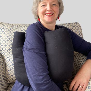 * This Breast cancer surgery support pillow ideal for use directly after surgery, or in the following weeks while healing takes place. * This support cushion is shaped to fit comfortably under the affected arm, and is filled with good quality polyester fibres to a fairly firm finish. This pillow reaches mid chest in width, so it will easily cover the surgery area, and provide support&nbsp; and padding.
I am a breast cancer survivor myself so I understand what is needed after having had chest surgery, and how important comfort and support are as healing occurs. I have sought advice from the Road Safety Authority in Ireland, in relation to the suitability of my pillows to be used when driving, if positioned under a seat belt. They recommend that I advise caution to customers on the use of aids that have the potential to interfere with any safety features in the car, and potentially increasing risk of injury. I want to ensure customers that I take their safety and security sincerely when ordering products from my shop.
It measures 43cm wide X 37cm long and 10 cm in depth. This plain black cotton fabric and is soft and breathable. All cushions come with a made with love by Rodgerson Handcraft label and are reversible.