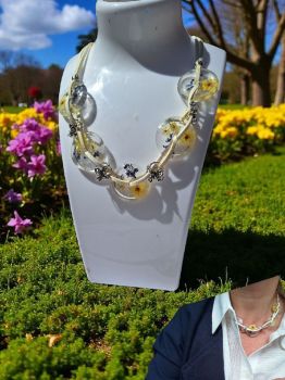 Statement floral necklace with real flowers in resin, faux suede cord and butterfly details. Lightweight, romantic and adjustable.
