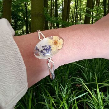 Oval floral bracelet with real dried flowers in resin. Silver-tone metal, adjustable cuff. Handmade &amp; nature-inspired.