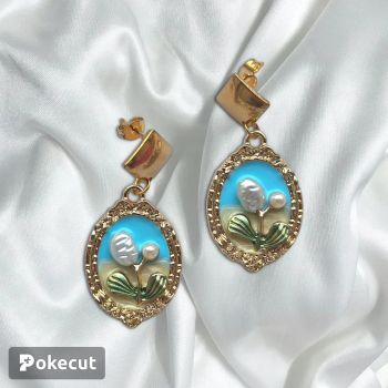A cute little golden framed earring with a lovely baby blue background and a white flower. Has a diamond shape earring stud making it an elegant design&nbsp;