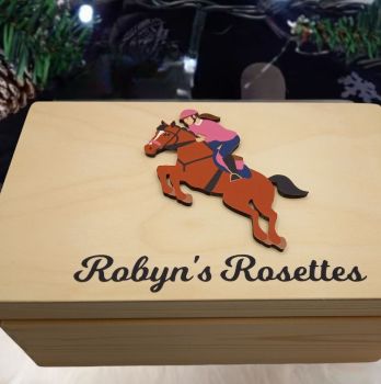 Personalised Horse Riding Rosette box, with option to put club crests on box. Choose male or female horse rider figure, hair colour and kit and hat colour. Box is finished with a non toxic wax.
The dimensions of the box are 29cm x 18cm x 13cm a very generous size to store all your well earned medals.
The ideal gift for any horse riding fanatics with a rosette haul and nowhere to store them. Leave them speechless with this personalised keepsake box, something they will have to cherish their medals . These personalised martial arts keepsake boxes are the perfect gift for a birthday, mothers day, fathers day, communion, confirmation or Christmas present. A truly unique gift.