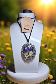 Vintage-style necklace with real dried flowers in clear resin and silver-tone frame. A nature-inspired accessory.