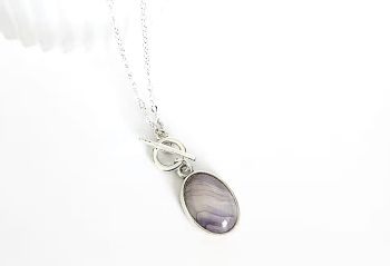 A beautiful antique silver framed banded agate, which is suspended from a silver plated chain and toggle clasp. The drop on this pendant is approx. 3.8cm/1.5ins including clasp. A gorgeous versatile pendant with a lovely natural gemstone...&nbsp; It arrives in a pretty organza bag, and has free shipping.&nbsp;&nbsp;
Banded agates are believed to offer stability, balance and grounding to the wearer, helping to harmonise the mind body and spirit, by promoting emotional stability and inner peace.
