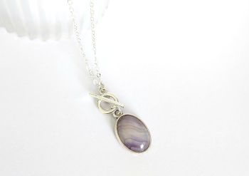 A beautiful antique silver framed banded agate, which is suspended from a silver plated chain and toggle clasp. The drop on this pendant is approx. 3.8cm/1.5ins including clasp. A gorgeous versatile pendant with a lovely natural gemstone...&nbsp; It arrives in a pretty organza bag, and has free shipping.&nbsp;&nbsp;
Banded agates are believed to offer stability, balance and grounding to the wearer, helping to harmonise the mind body and spirit, by promoting emotional stability and inner peace.