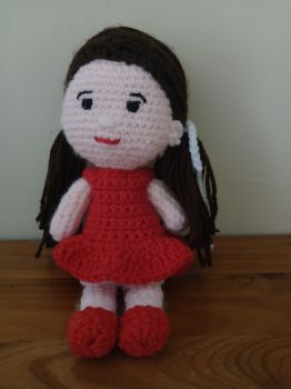 Crochet doll in red dress and pigtails