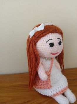 Cute crochet doll with auburn hair.