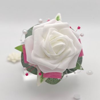 A pretty keepsake debs flower corsage made with an artificial white rose and attached to a white pearl bracelet.&nbsp;