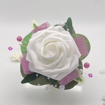 A pretty keepsake debs flower corsage made with an artificial white rose and attached to a white pearl bracelet.&nbsp;