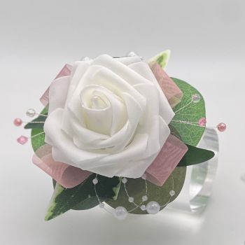 A pretty keepsake debs flower corsage made with an artificial white rose and attached to a white pearl bracelet.&nbsp;