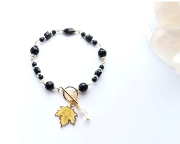 Handmade gold plated bracelet, created with acrylic beads in black, cubed, faceted glass beads also in black, gold plated beads and toggle clasp. It also has a beautiful gold plated, enamelled leaf charm and iridescent glass bead charm. ( bracelet length, incl. clasp, approx. 20.9cm/8.25ins). A lovely lightweight, bespoke bracelet, perfect for autumn&hellip;. Elevate your style with this lovely piece&hellip; It arrives in a pretty organza bag, and has free shipping!