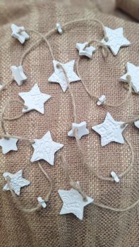 Handmade with air dry clay, this gorgeous rustic garland comprises of 21 stars varying sizes from 1cm - 4cm. It's approx 1.7 metres in length. Each star is tied in place to a length of jute string. Some.stars are plain and others are imprinted with a lace/ pattern.
These clay decorations will last for years and years once used indoors only and stored away from damp conditions