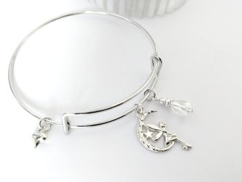 Gorgeous polished stainless steel adjustable bangle, with a silver plated fairy charm, iridescent glass bead, and a tiny silver plated heart charm. Light and easy to wear, cute and perfect for lovers of all things whimsical...&nbsp; It arrives in a pretty organza bag, and has free shipping
