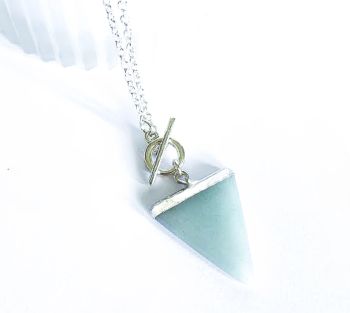 Beautiful handmade pendant, created with a silver framed natural amazonite stone, suspended from a silver plated chain and toggle clasp. The chain is approx. 50cm/ 20ins in length, the pendant is approx. 3.2cm/1.25ins in length. A gorgeous lightweight pendant, easy to wear and very versatile… Elevate your look with this beautiful bespoke piece! Please note:- As this is a natural gemstone, it may have flaws and inclusions, which are part of its natural formation. It arrives in a pretty organza bag, and has free shipping!
Amazonite is believed to filter stress and anxiety, encourage self-worth, and foster emotional balance..