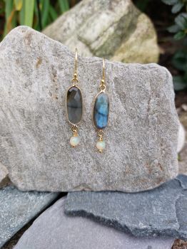 A long oval faceted Labradorite is bezel set. A 3.5mm round Opal bead drops from the setting. The earrings are handmade in gold plated Sterling Silver.