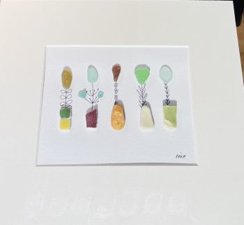 Sea glass flowers in tile vases! Sea glass was hand picked &nbsp;from the beaches and rocks of Sandycove Co Dublin. Each piece is unique and handmade locally. Frames with glass fronts panel are sourced from Wicklow. Free postage in Ireland . Give a sustainable handmade Irish gift!