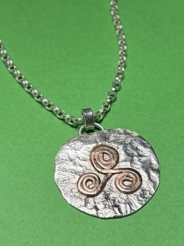 Silver pendant with copper Triskele&nbsp;
Necklaces are made to order, depending on length chosen.&nbsp;
I create with recycled silver. I use copper that has been recycled into wire or sheet metal. Any coins that I use have been circulated but are in good condition. I use different materials, but all are recycled.&nbsp;