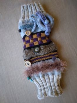 A handmade knitted handwarmer with different textures, colours and attachments for sensory experience. Beneficial for Dementia patients. Adult size.