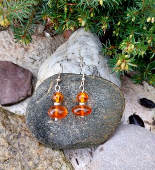 Two natural Amber beads and a Sterling Silver bead drop from a Sterling Silver earwire.&nbsp; These are handmade here in Ireland.