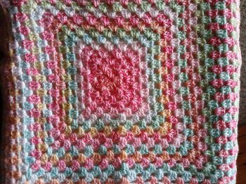 Unique baby gift, granny square style pram blanket in rainbow colours.