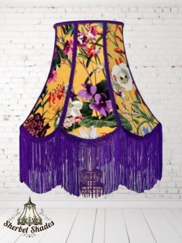 Handmade artisan lampshade
Vibrant floral print on warm golden base
Bold purple trim and long fringe detail
Unique scalloped panel design
Creates a warm, atmospheric glow when lit
&nbsp;