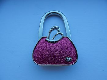 Handbag hooks are a functional accessory and very easy to use.
Perfect to keep your bag off the floor and allows you keep your bag in view at all times.
The hanger is slim,light and fits neatly in your bag or purse. It can also be hung on your bag as a decoration.
Deep pink&nbsp; glitter handbag shaped bag hook.