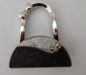 Handbag hooks are a functional accessory and very easy to use.
Perfect to keep your bag off the floor and allows you keep your bag in view at all times.
It can also be hung on your bag as a decoration.
Black&nbsp; &amp; silver glitter handbag shaped bag hook.