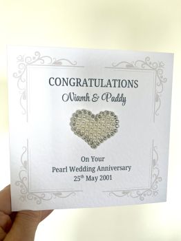 Pearl Wedding Anniversary Card &ndash; 6x6 Luxury Hammer Card Stock
Celebrate a love that has stood the test of time with this exquisitely crafted pearl wedding anniversary card. Designed on premium 6x6 hammer-textured card stock, it offers a tactile elegance that feels as special as the occasion itself.
Each card is&nbsp;personally customised&nbsp;with the couple&rsquo;s names and wedding date, transforming it into a meaningful keepsake rather than just a greeting.
At its heart lies a delicate&nbsp;pearl and diamante embellishment, forming a timeless heart motif that gently catches the light. It adds just the right whisper of sparkle, like a quiet toast to decades of shared memories.
The minimalist yet sophisticated design makes it perfect not only for gifting, but also for&nbsp;framing alongside a cherished photograph, allowing it to live on as part of the couple&rsquo;s story.
Features:

6x6 inch square format
Premium hammer-textured card stock
Personalised with names and wedding date
Elegant pearl &amp; diamante heart detail
Ideal for framing as a keepsake

A card that doesn&rsquo;t just mark the day&hellip; it becomes part of the legacy. 💍✨