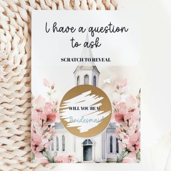 The Most Beautiful Way to Ask ⛪️🌸
Imagine handing this gorgeous card to your best friend, your sister, or the person you&rsquo;ve chosen to stand beside you on your wedding day. She reads "I Have a Question to Ask&nbsp; Scratch to Reveal" in elegant black script, picks up a coin, and scratches away the gold circle to discover: "Will You Be My Bridesmaid?" That moment of pure, breathless joy&nbsp; handmade in Ireland by Printarelle.

Featuring a dreamy watercolour scene of a white chapel framed by oversized blush pink sweet peas and soft green foliage&nbsp; romantic, feminine, and utterly wedding-perfect. The gold scratch-off circle sits right at the heart of the chapel illustration, making the reveal feel truly magical.