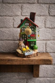 Handmade miniature cottage scene crafted from reclaimed wood and air-dry clay, featuring a hand-painted house, a tiny cat on a flour sack, and delicate dry flowers as an accent.&nbsp; 18/9 cm!