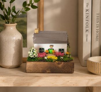 A beautiful, artisan-made miniature Irish cottage crafted from reclaimed wood. Features a hand-painted finish and a vibrant garden. A rustic, one-of-a-kind piece of Irish-inspired folk art.&nbsp; 8/6/7 cm!