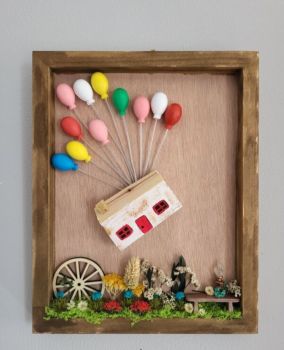 A whimsical frame featuring a handcrafted wooden cottage floating with colorful balloons. Decorated with real dried flowers and rustic elements, this unique wall art brings a touch of colour to any room. 25/20 cm.