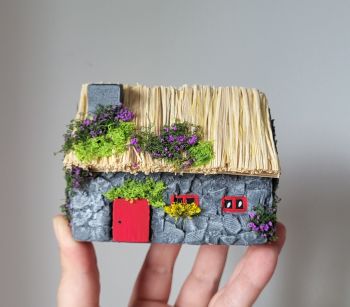 Capture the magic of Emerald Isle with this handcrafted miniature cottage made from reclaimed wood and a traditional thatched roof. The vibrant red door and windows are hand-painted.&nbsp; 10/5/7 cm.