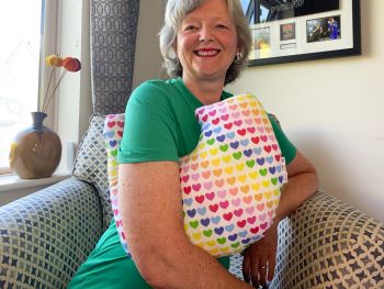 My breast cancer surgery support pillows are ideal for use directly after surgery, or in the following weeks while healing takes place. This support pillow is shaped to fit comfortably under the affected arm, and is filled with high quality polyester filling to a fairly firm finish, perfect to provide adequate support and comfort. This pillow reaches mid chest in width, so it will easily cover the surgery area, and provide support&nbsp; and padding.
It measures 43cm wide X 37cm long and 10 cm in depth. This multicoloured love hearts print fabric is soft and breathable. All pillows come with a handmade with love by Rodgerson Handcraft label and are reversible.