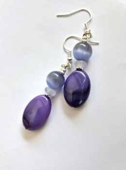Beautiful earrings, handmade in Ireland with quality materials, created with acrylic marbled drops in purple, gorgeous glass beads in varying shades of purple and silver plated beads. Suspended from silver plated, nickel free ear hooks. Light and comfortable to wear.&nbsp; Great for gifting or a personal treat!&nbsp; &nbsp;They arrive in a pretty organza bag, and have free shipping!