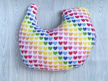 This gift set combines breast cancer surgery recovery pillow and matching chemo port seatbelt pillow are ideal for use directly after surgery, or in the following weeks while healing takes place. This BC support pillow is shaped to fit comfortably under the affected arm, and is filled with high quality polyester filling to a fairly firm finish, perfect to provide adequate support and comfort. This pillow reaches mid chest in width, so it will easily cover the surgery area, and provide support&nbsp; and padding. The chemo port support pillow gives support when used in a car while treatment is ongoing and afterwards.
The BC pillow measures 43cm wide X 37cm long and 10 cm in depth. This multicoloured love hearts print fabric is soft and breathable. All pillows come with a handmade with love by Rodgerson Handcraft label and are reversible.