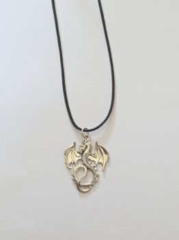 A charm of a dragon with open wings on a black leather rope necklace.