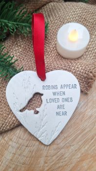 BESTSELLER A handmade clay heart featuring the popular sentiment &lsquo;robins appear when loved ones are near&rsquo; . Indoor use only The item is sent out as pictured on jute string with a piece of festive ribbon or on a length of festive ribbon Heart measures 8 cm approx INDOOR &nbsp;use only and please allow up to two weeks processing.