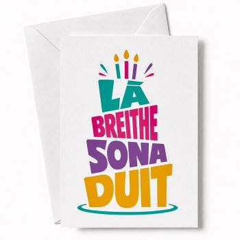 BOLD TYPOGRAPHIC IRISH BIRTHDAY CARD: "L&aacute; Breithe Sona Duit" fills this card in a striking cake-shaped typography design, in teal, pink, purple, and gold. The phrase forms the cake itself, with candles on top. Graphic, contemporary, and full of energy.
