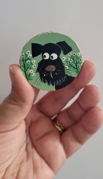 Unique hand-painted wooden magnet features a cute black dog with a soft background and tiny white flowers!