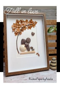 🍂 Fall in Love with Autumn 🍂There&rsquo;s something so magical about this time of year &mdash; the gentle rustle of leaves, cosy colours, and that feeling of warmth in the air.This handmade pebble art picture captures all of that and more 💛 A couple stands beneath an autumn tree made from dried hydrangea flowers in rich, warm browns. The girl&rsquo;s ivory shell skirt and their little dog beside them add a touch of sweetness, while the brown frame beautifully complements the autumn tones.Perfect as a wedding or anniversary gift, this piece can be personalised with names and a date &mdash; and there&rsquo;s even the option to add a delicate veil for the bride 👰&zwj;♀️This picture comes on a brown wooden frame of approximately 32 x 23cm (12.5 x 9"). It can be wall hanged or rested on a table.Lovingly handmade and ready to ship within 2&ndash;3 days.