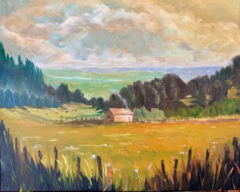 Bring the Irish Countryside Into Your Home
This original oil painting captures a quiet moment in the rural landscape &mdash; a small stone cabin nestled among deep green trees, a whisper of smoke rising from its chimney, and a sun-drenched golden meadow stretching out before it, alive with white and blue wildflowers.