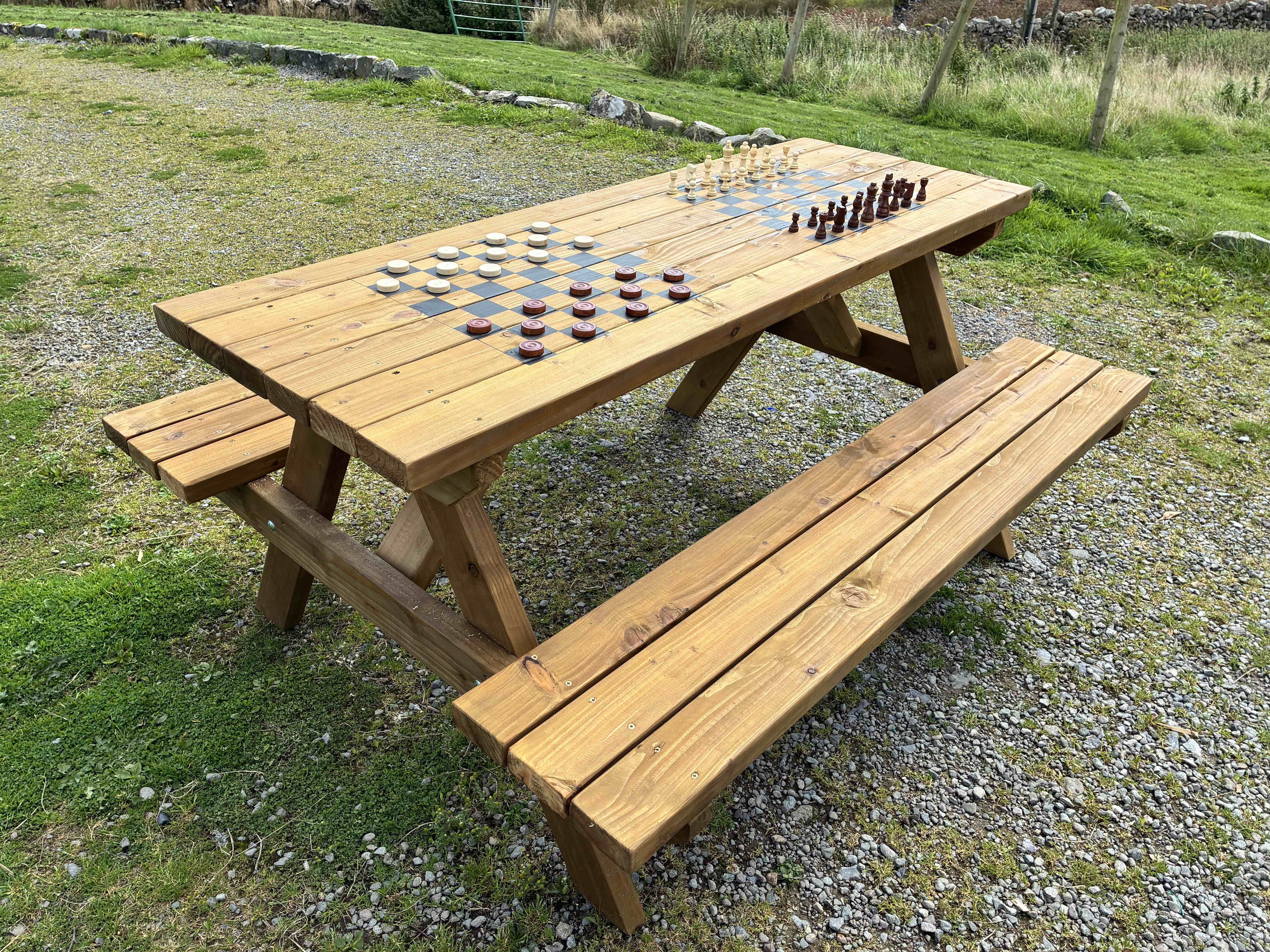 A&nbsp;beautifully&nbsp;handcrafted&nbsp;wooden&nbsp;picnic&nbsp;bench&nbsp;with&nbsp;integrated&nbsp;chess&nbsp;and&nbsp;chequers&nbsp;boards,&nbsp;combining&nbsp;traditional&nbsp;outdoor&nbsp;seating&nbsp;with&nbsp;classic&nbsp;games.

Perfect&nbsp;for&nbsp;Playgrounds
Encourages&nbsp;teamwork&nbsp;&amp;&nbsp;strategic&nbsp;thinking
Fun&nbsp;for&nbsp;all&nbsp;ages
Practical&nbsp;&amp;&nbsp;unique&nbsp;addition&nbsp;to&nbsp;any&nbsp;outdoor&nbsp;space

Measures approx 1.6m length. Constructed from pressure treated timber and finished in natural oil. Includes one set of Chess &amp; Chequers pieces.