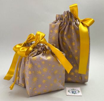 This gift bag set are made using grey and gold starred fabric. This gift bag set includes 2 gift bags. They are finished to a high standard, and are drawstring tied with coordinating gold ribbon. It is reusable gift wrapping and will make a great tradition for wrapping Christmas presents.&nbsp;