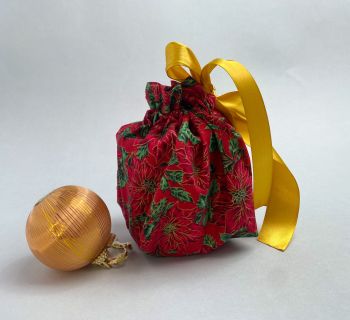 This gift bag are made using red poinsettia fabric. This gift bag includes 1 gift bag. It is finished to a high standard, and is drawstring tied with coordinating gold ribbon. It is reusable gift wrapping and will make a great tradition for wrapping Christmas presents.&nbsp;