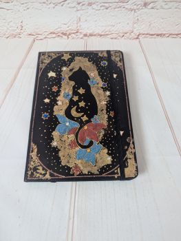 A lined, undated notebook with a hand-painted black and gold cat design, finished with metallic and rhinestone details.