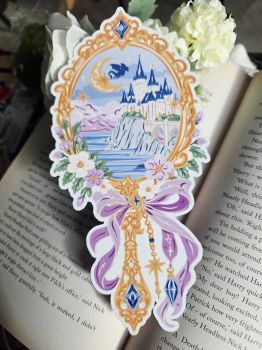 ​Bring a touch of magic to your reading routine with this stunning, fantasy-inspired bookmark! Featuring an ornate golden frame, a dreamy coastal castle, a soaring dragon under a crescent moon, and delicate floral and bow detailing, this piece is a must-have for any fantasy or romance book lover.&nbsp;
