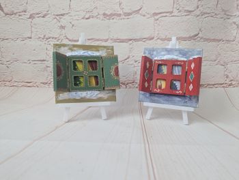 Hand-painted 10 &times; 10 cm Christmas miniatures with opening shutters and a festive scene inside. Mini easel included.