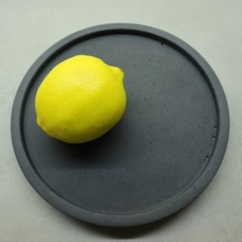 Minimalistic, sleek round concrete tray is a real statement piece and is so versatile, offering endless possibilities for its use. It can also be used indoors and outdoors to hold all your favourite bits and pieces, or those bits and pieces that hide in your pocket &amp; usually end up on the table /countertop at the end of the day; let your things have their own space&hellip;.a podium if you will. Each item is unique due to the shade of colour and texture that is formed by air bubbles when pouring the concrete mixture. All items are sealed to help protect from any spillage / dirt / dust. Please use a damp cloth to gently wipe away any spills, dust etc. Size: diameter 19.5cm (outer), 17.5cm (inner), height 2cm, all trays have foam padding to protect the surfaces from scratching. Weight: ~0.9 kg. Tray is available in 3 colours &ndash; white, grey or charcoal.